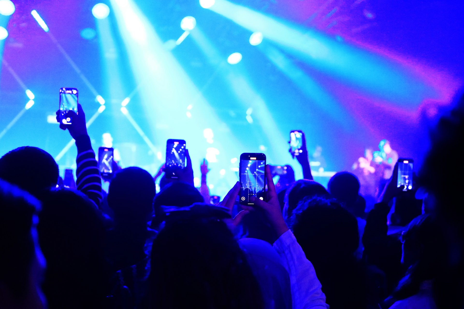 A concert crowd filming on their phones