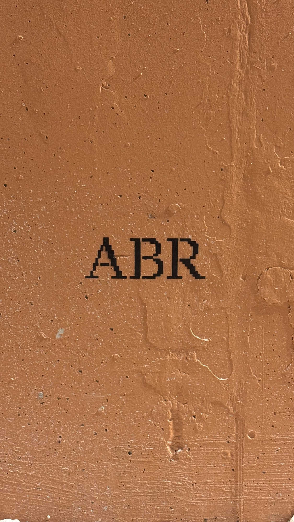 The ABR stencil on the orange wall