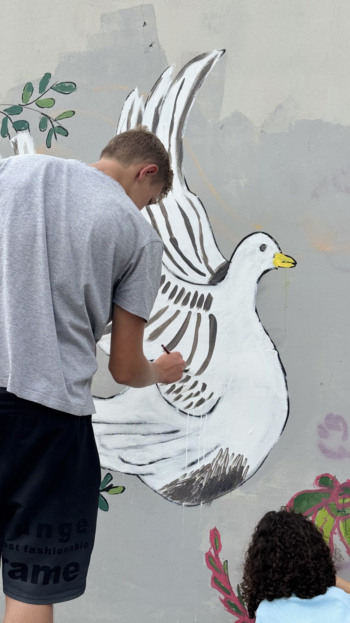 A young painter adding to the dove