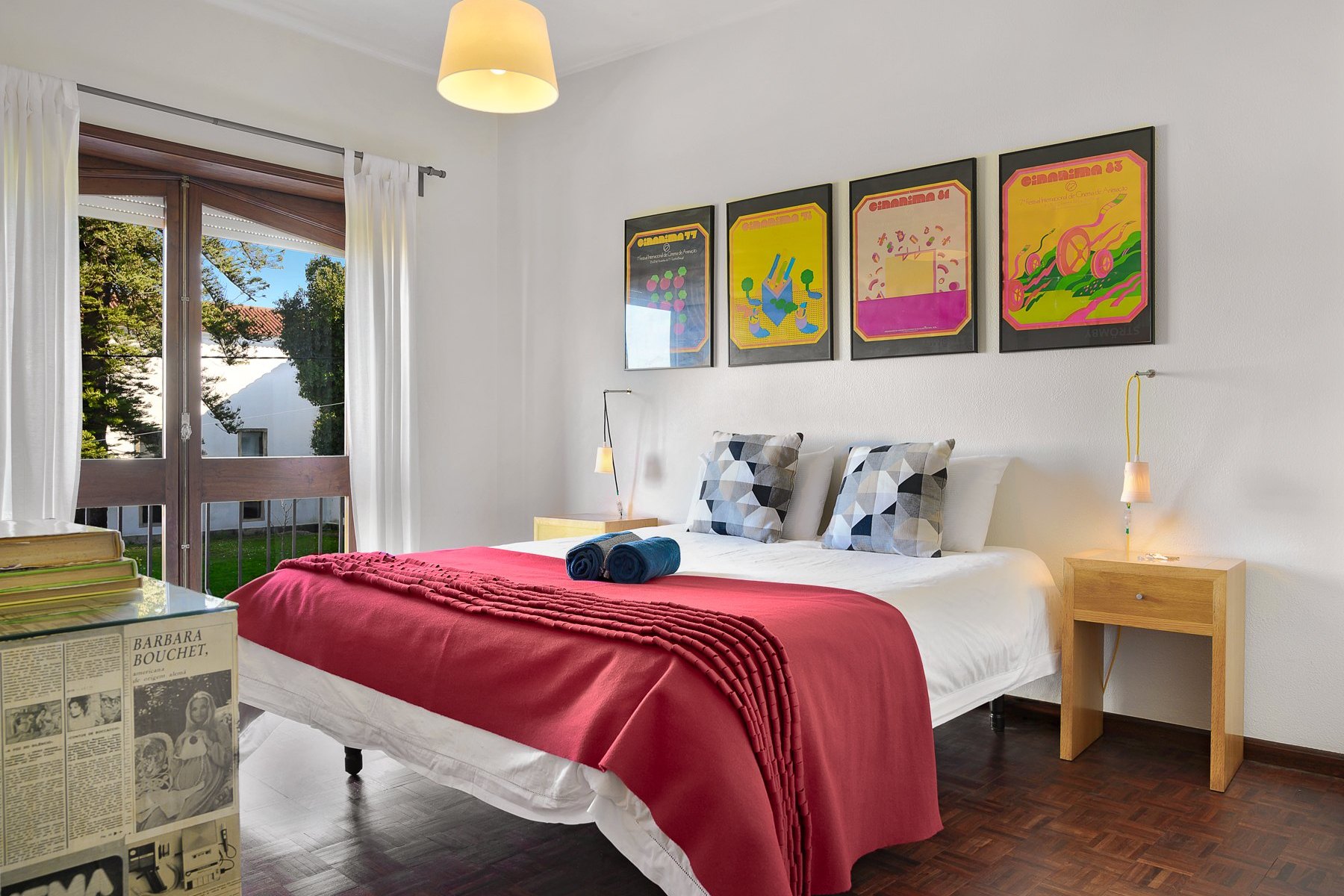 A guest house bedroom with framed prints above the bed