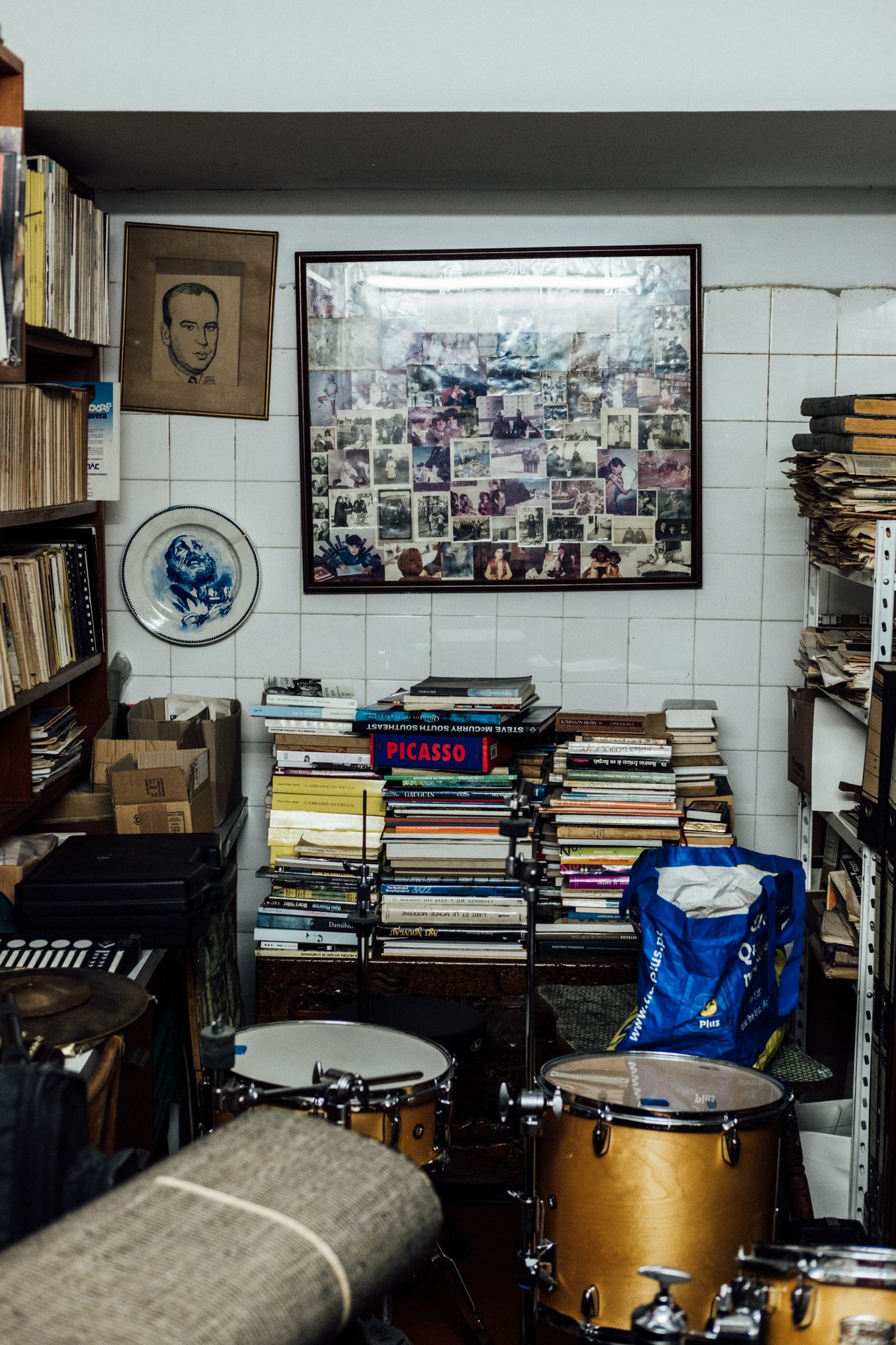 A room of books, records, a framed photo wall and drums