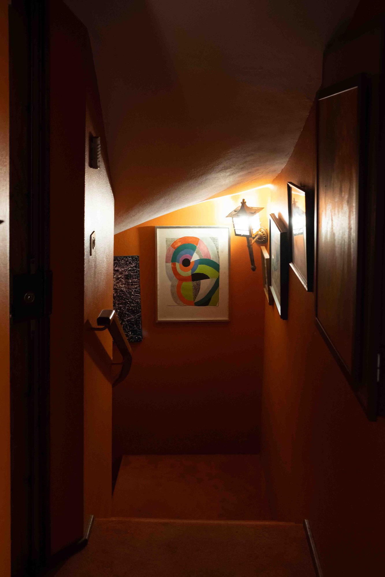 A warm, lamp-lit stairwell inside the house
