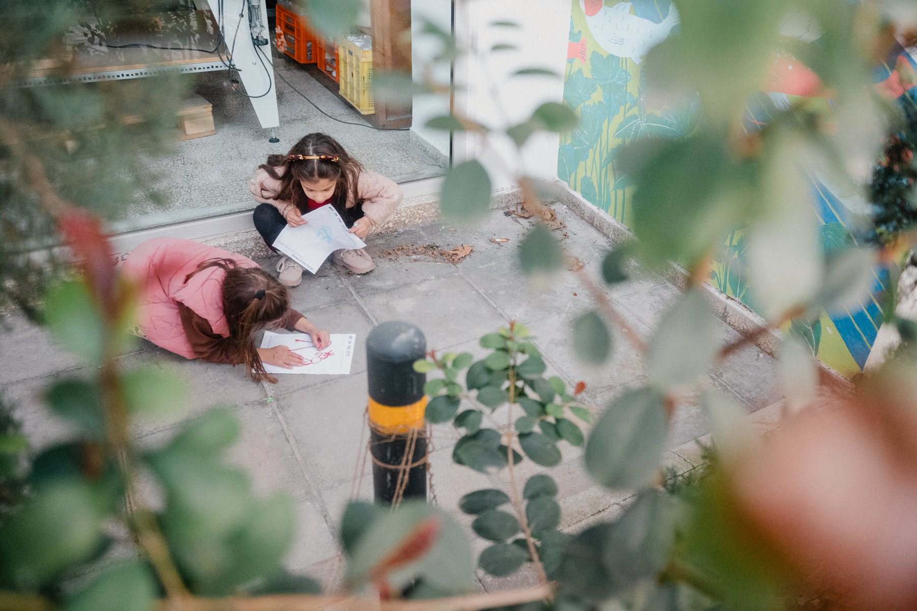 Kids drawing beside the mural